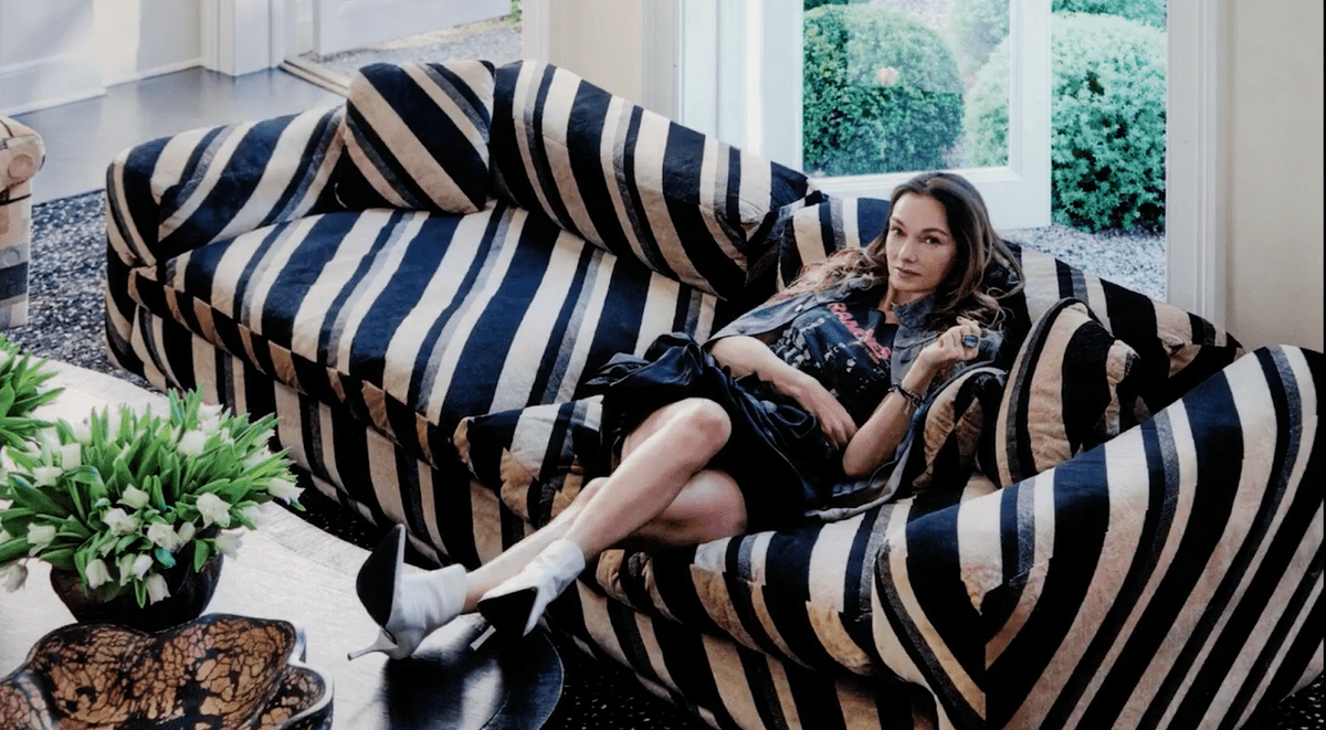 Kelly Wearstler poses on a striped couch