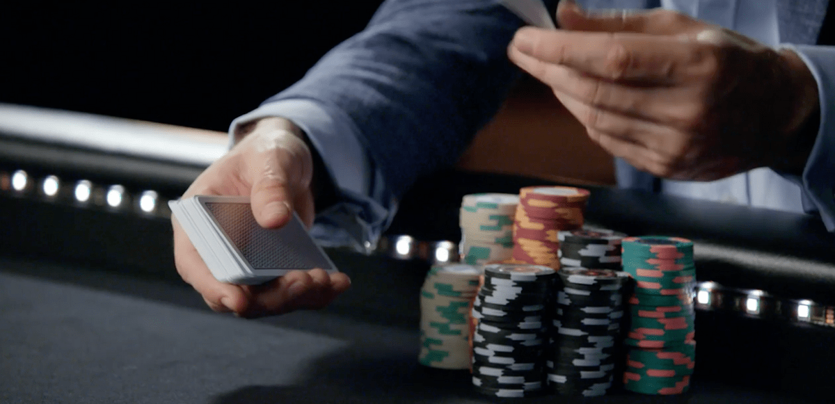 Daniel Negreanu dealing cards with a large pile of chips