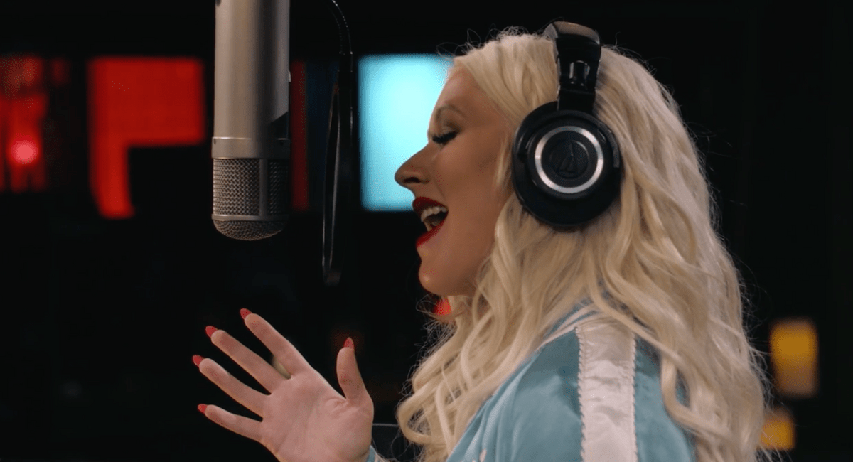 Christina Aguilera singing into a studio microphone