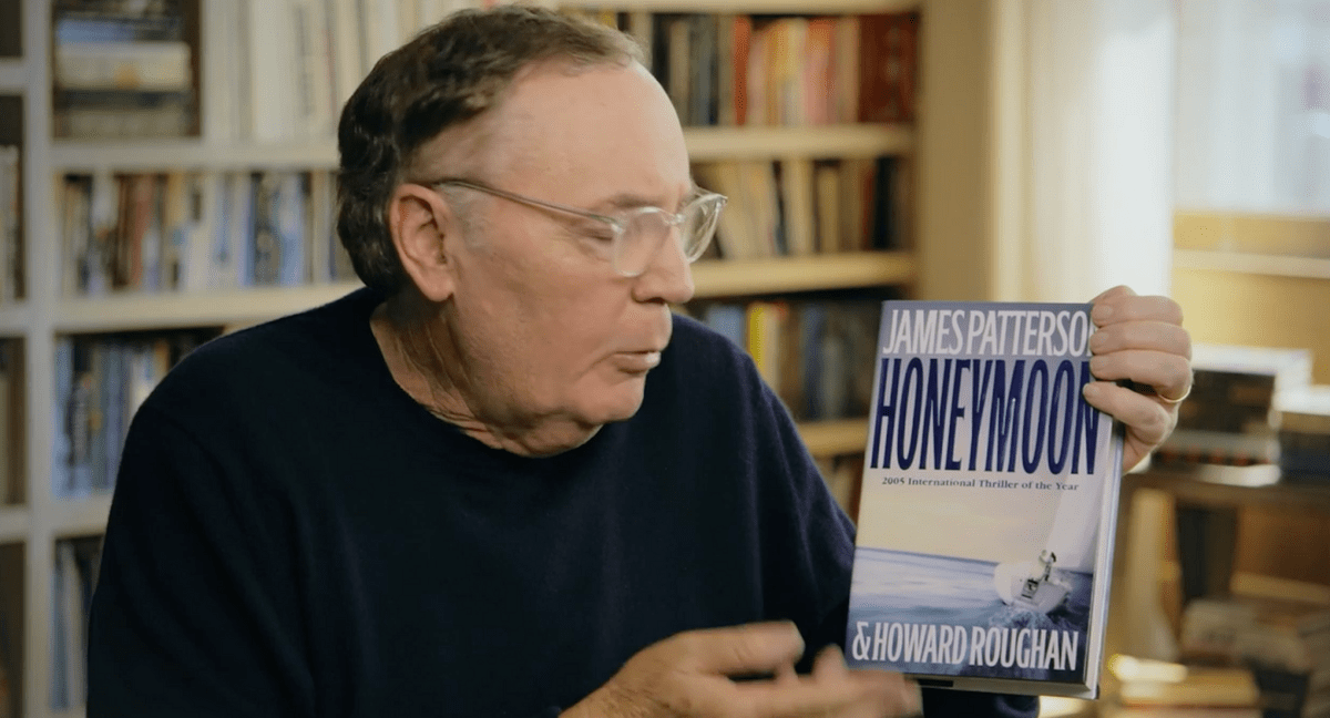 James Patterson holding a copy of his book Honeymoon