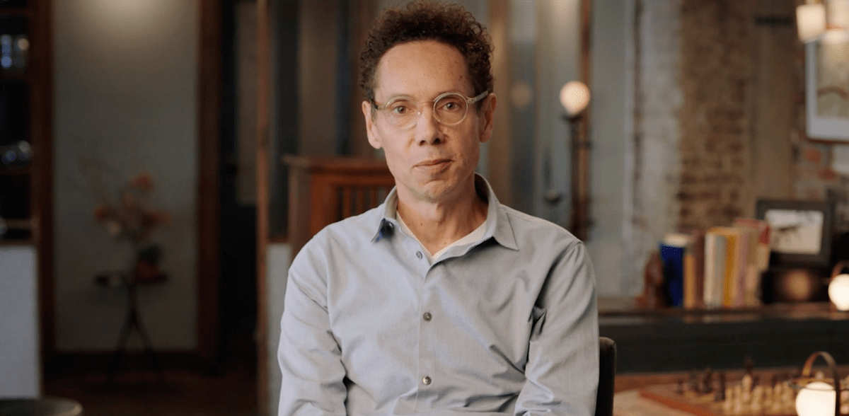 Writer Malcolm Gladwell sitting in a chair