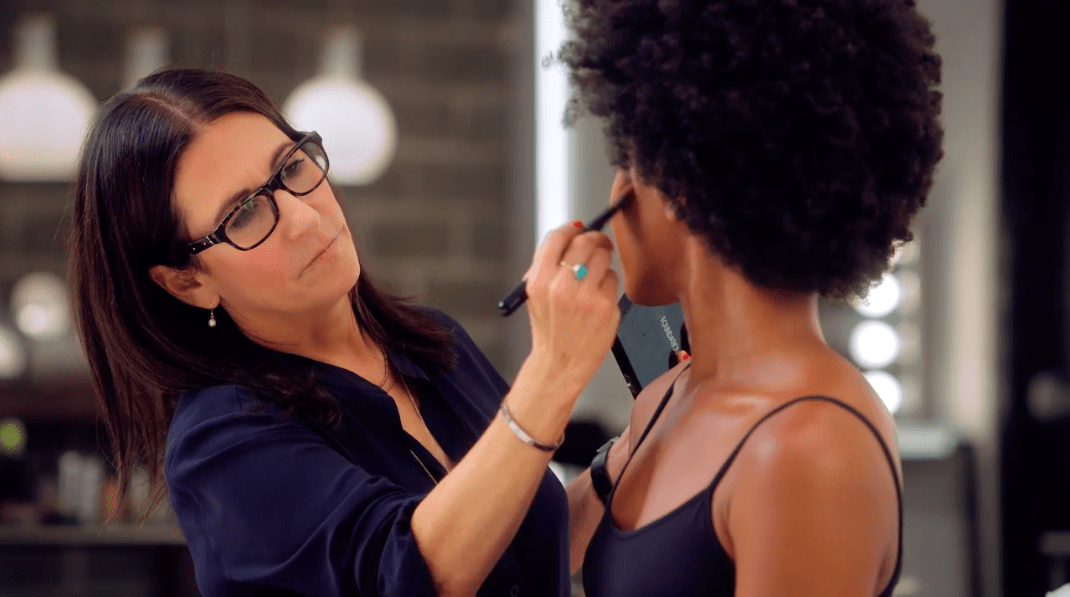  Bobbi Brown brushing makeup on model