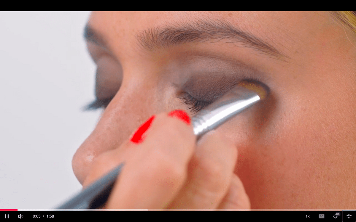 Hand applying eyeshadow to model